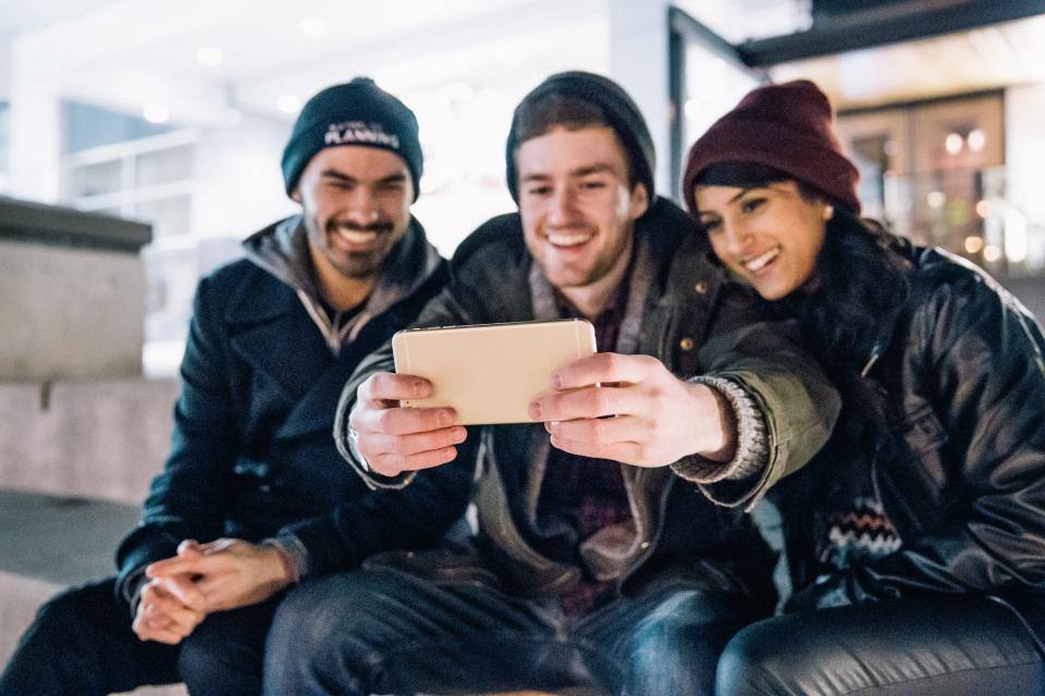 Tres amigos mirando juntos un celular